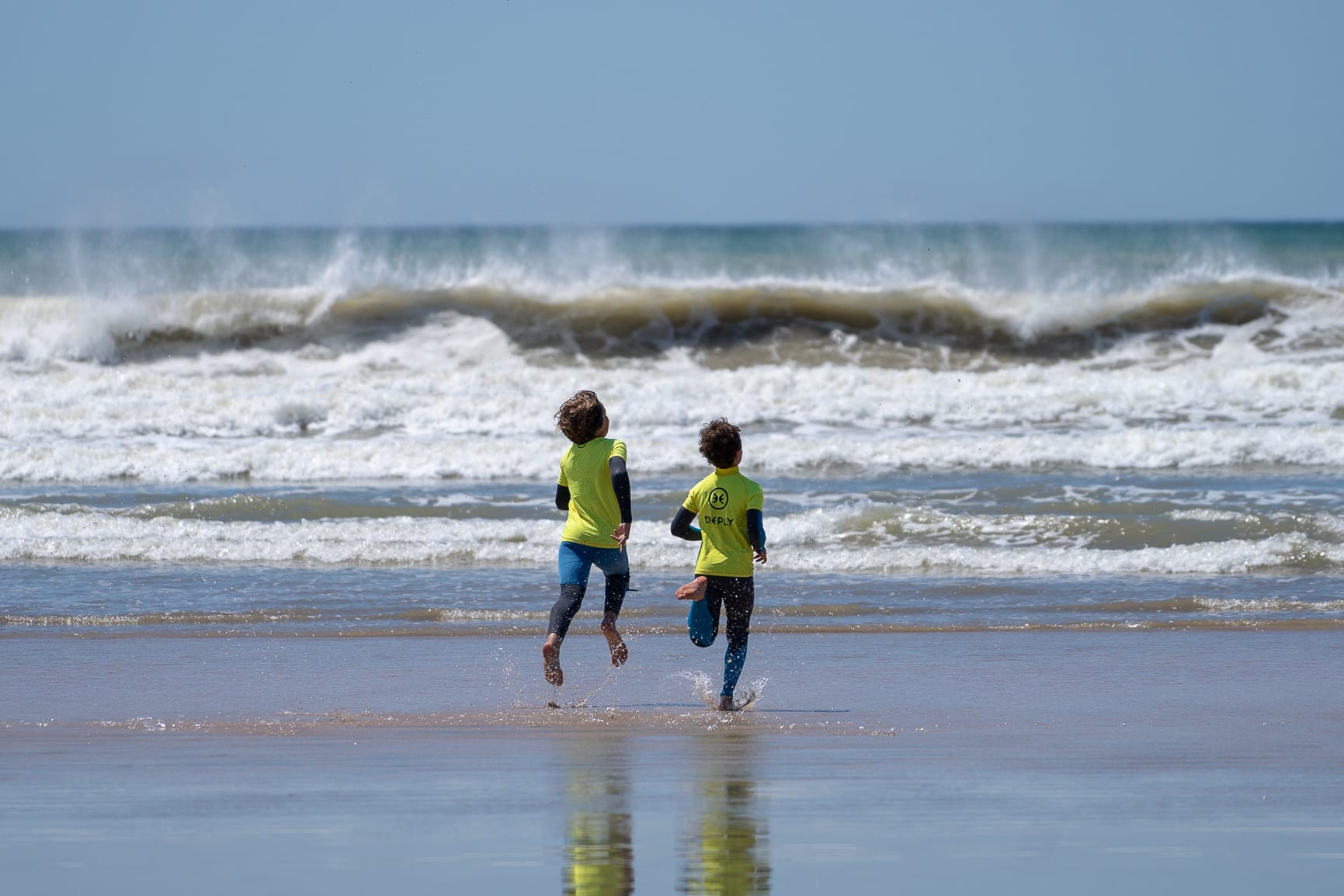 enfants-vagues-ocean-soleil-sable-combinaison-surf-formule-cours-lycra