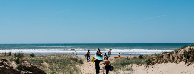 arrivee-plage-sable-planche-surf-combinaison-enfant-adulte-ado-coach-vegetation-soleil-ciel-bleu